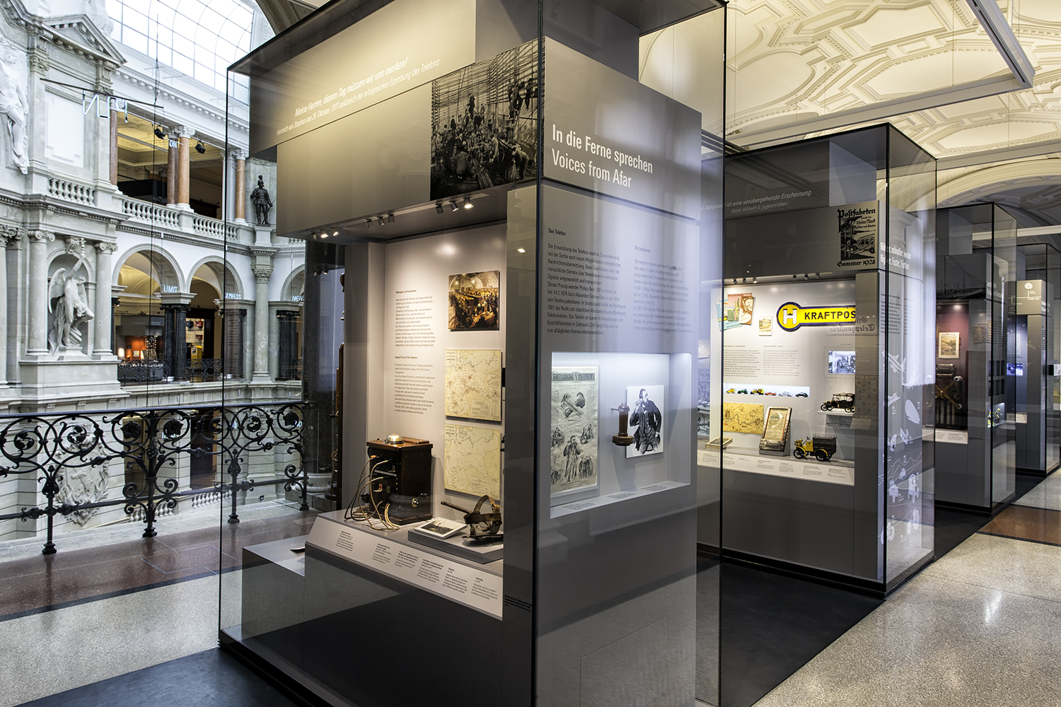 Blick auf Ausstellungsvitrinen mit Lichthof im Hintergrund