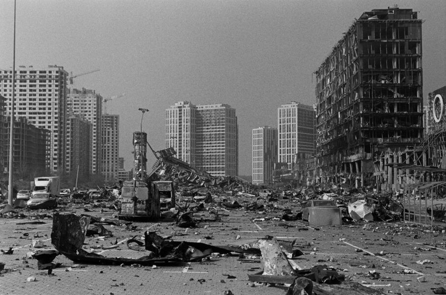 In schwarz-weiß eine Stadt die in Trümmern liegt. Im Hintergrund sind noch stehende Gebäude.