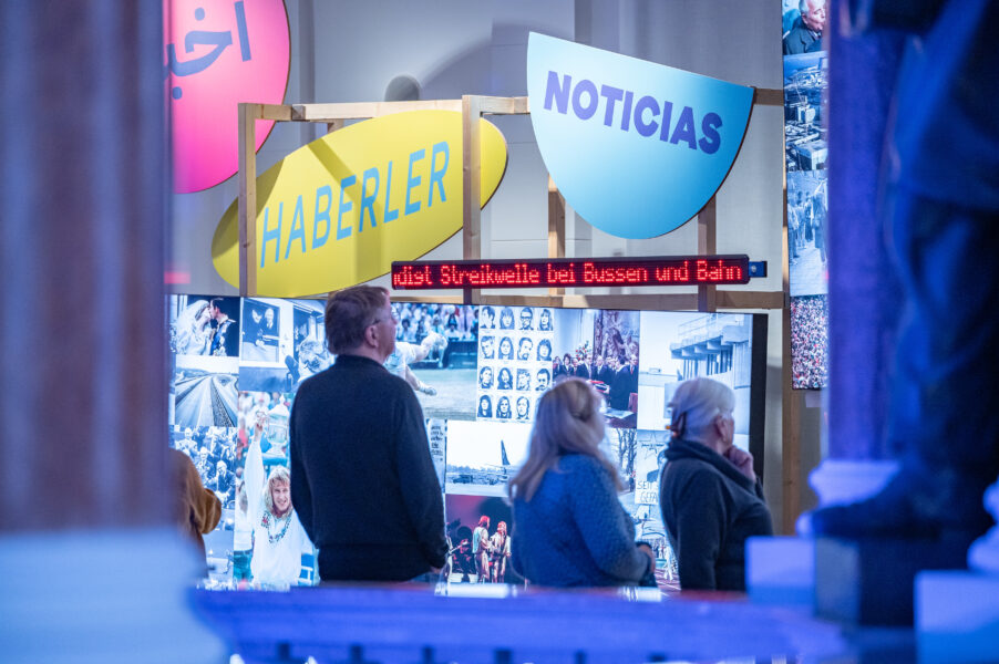 Blick in die Ausstellung mit Menschen und Text- und Bildtafeln