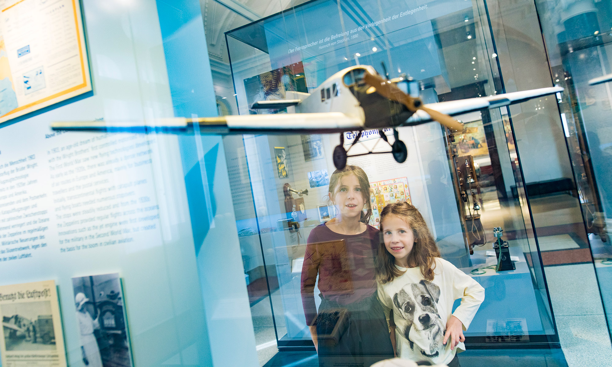 Zwei Kinder in der Dauerausstellung vor einem Modelflugzeug