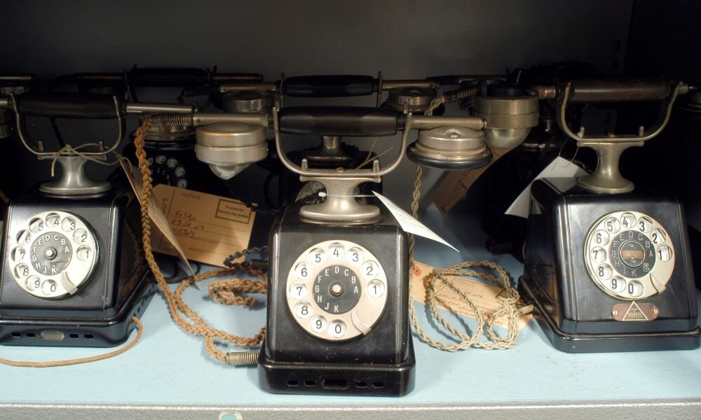 Drei alte Telefone mit Wahlscheibe.